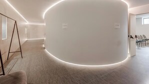 A modern interior with a curved wall, a seating area with chairs, and a small table.