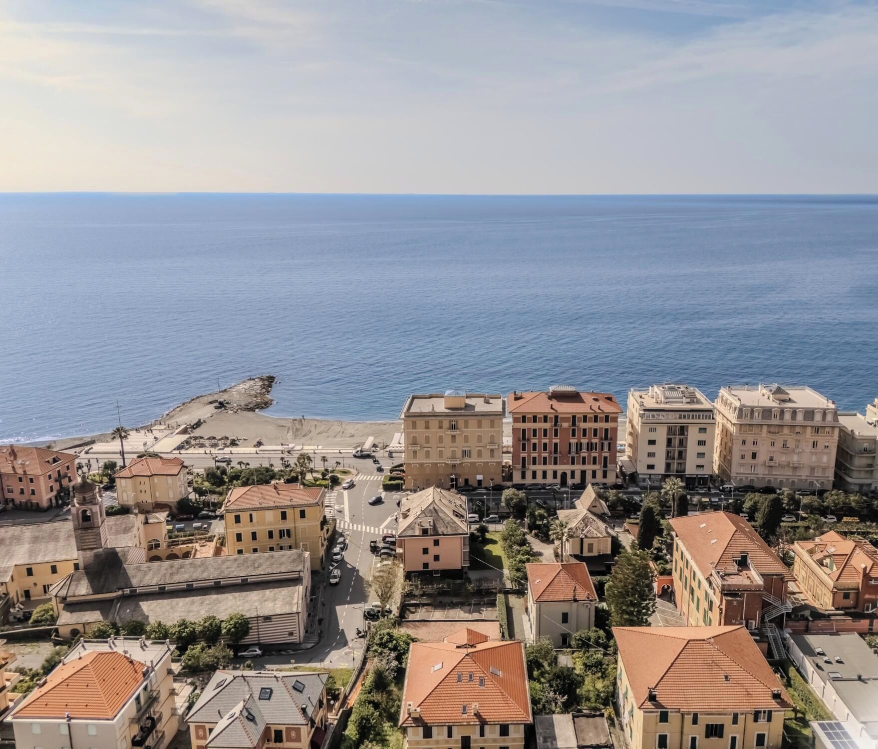 Une ville côtière avec des bâtiments, une plage et un ciel dégagé.