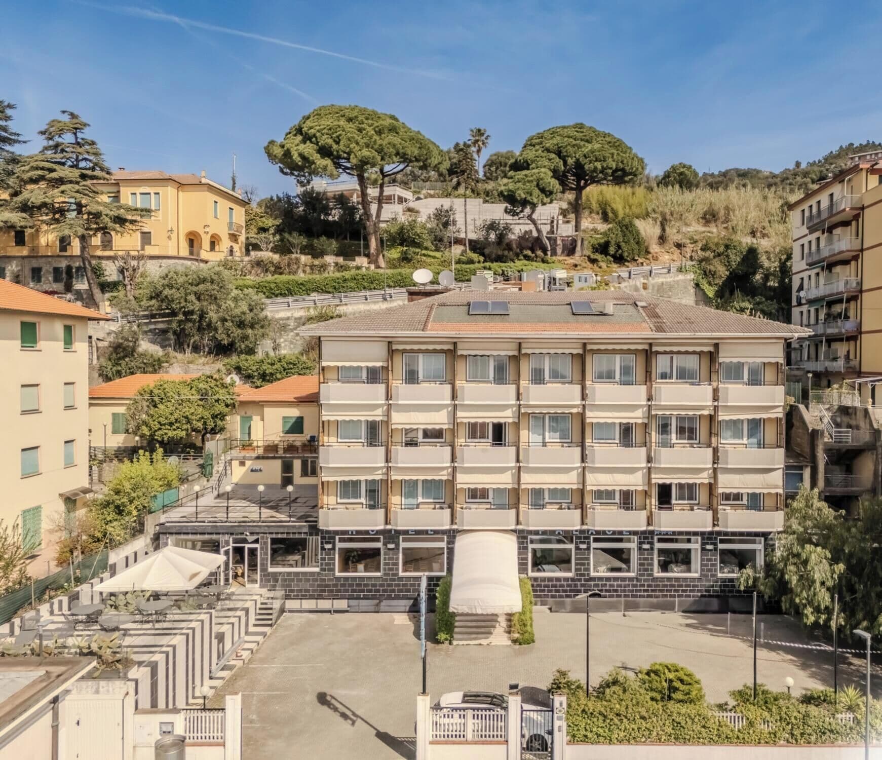 Un hotel de varios pisos con un patio central, rodeado de otros edificios.
