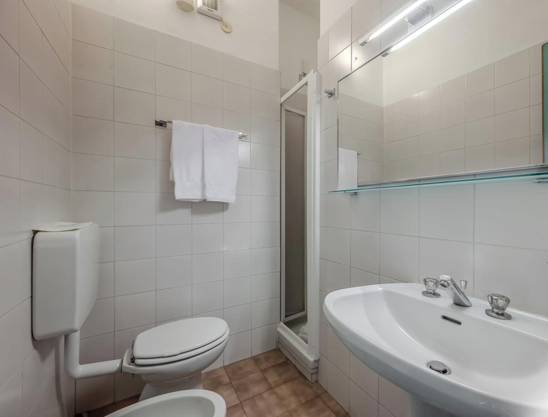 Un baño con inodoro, lavamanos y ducha.