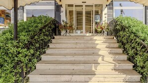 A set of stone steps leading to a building entrance with a covered area above.