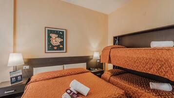 A hotel room with two beds, a nightstand, a lamp, a framed picture on the wall, and a sign with QR code.