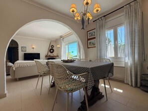 A dining area with a table, chairs, and a chandelier. - Holiday home Bel Coll 8p airco pool and views (L'Escala)