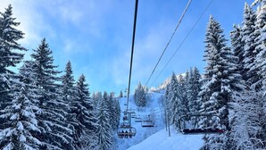 A ski lift with snow-covered trees and a clear sky.