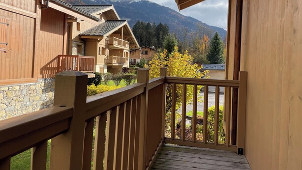 A wooden building with a balcony overlooking a mountainous landscape.