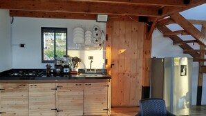 Keittiössä on puinen keittiösaareke, liesi, pesuallas ja jääkaappi.