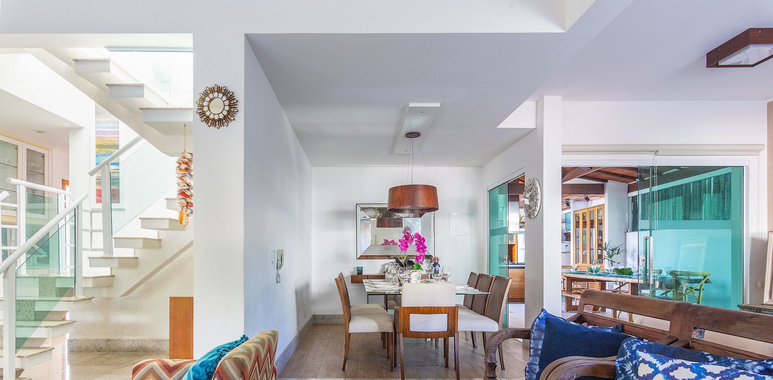 A modern interior with a staircase, dining area, and kitchen.