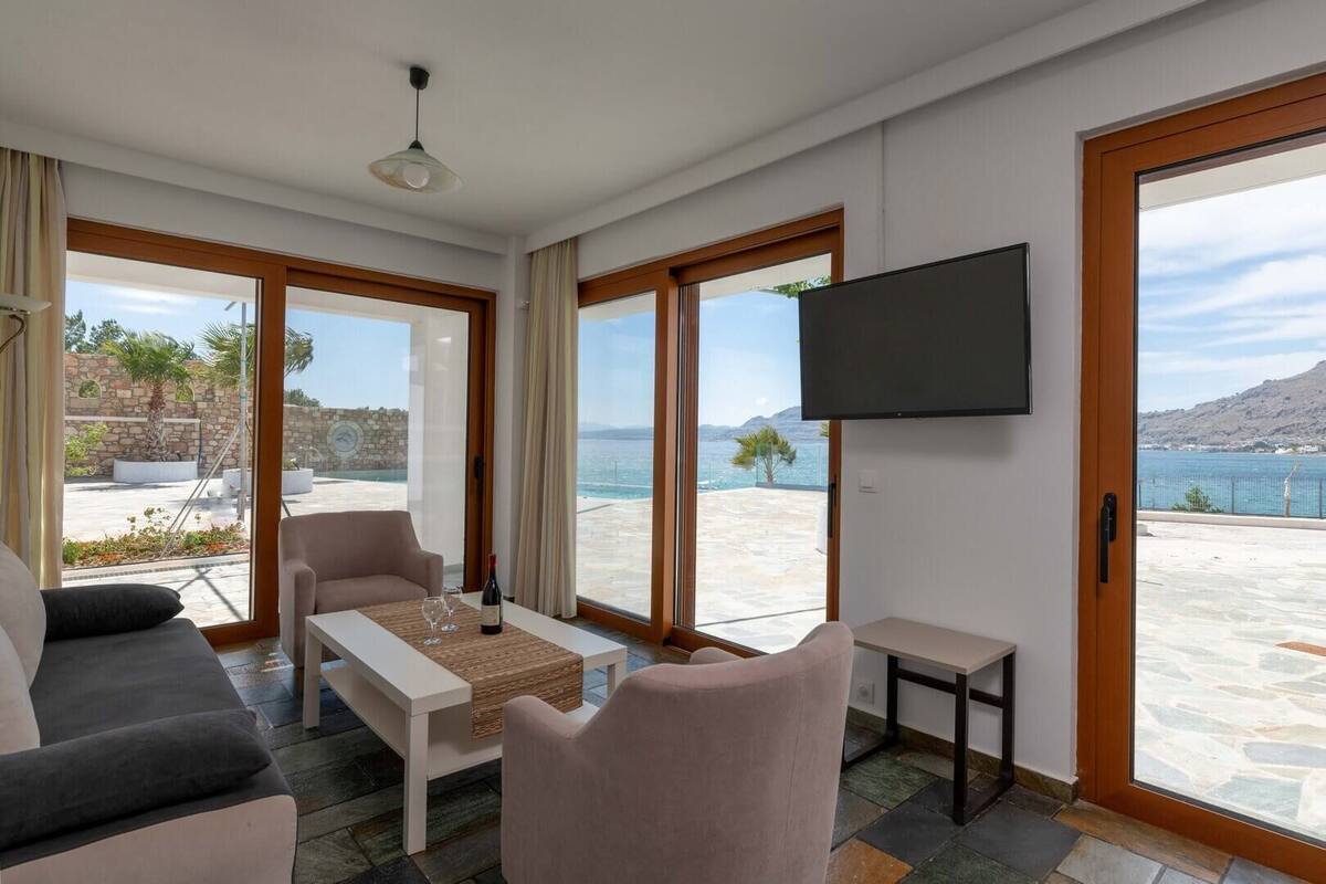 A modern living room with a sofa, a coffee table, and a TV mounted on the wall.