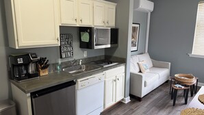 A modern kitchen with white cabinets, a stainless steel dishwasher, a coffee maker, and a sink. - Spacious little condo at SML- Mariner's Landing Resort (Huddleston)