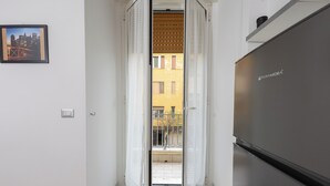 A narrow hallway with a door leading to a balcony. A stainless steel refrigerator is visible on the right. - Civico 79 - Two Bedroom Apartment, Sleeps 4 (Naples)