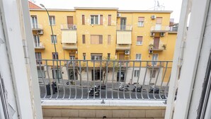 A yellow apartment building with balconies, a gated balcony area, and parked scooters. - Civico 79 - Two Bedroom Apartment, Sleeps 4 (Naples)