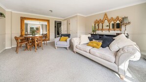 A spacious living room with a dining area, a large mirror, and a fireplace. - Spacious and pet-friendly stay near New Forest (Totton)