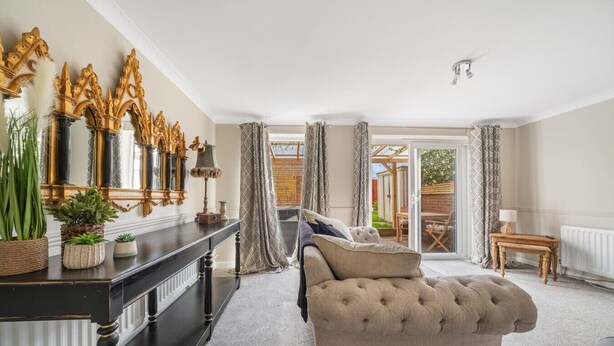 A room with a large window, a sofa, a console table with decorative items, and a view of the outdoors. - Spacious and pet-friendly stay near New Forest (Totton)
