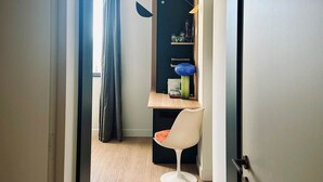 A modern room with a wooden desk, a chair, and a hanging light fixture. - MALACHITE (double room) (Carcassonne)