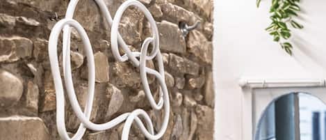 Una escultura blanca y abstracta sobre una pared de piedra.