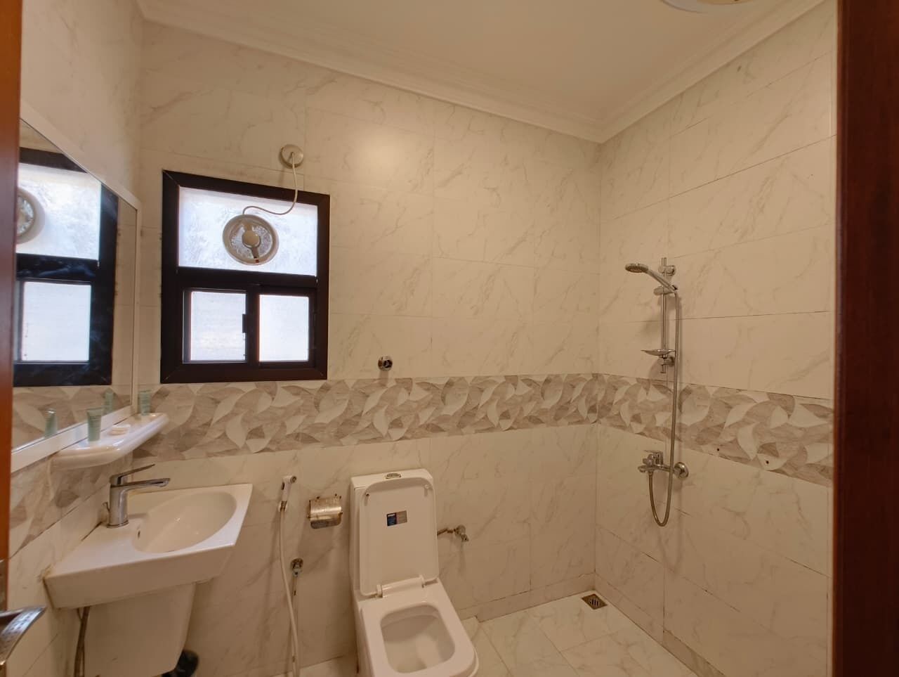 A bathroom with a toilet, sink, and shower.