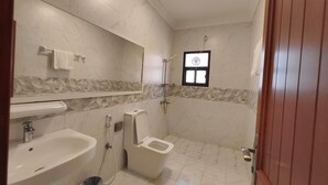 Uma casa de banho com lavatório, sanita e chuveiro.
