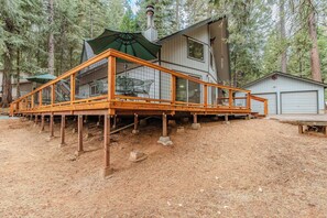 A wooden deck with a glass enclosure, a covered outdoor seating area, and a garage.