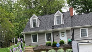 Une maison d’habitation avec un jardin devant, une boîte aux lettres et une allée.