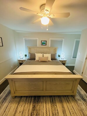 A bedroom with a large bed, a ceiling fan, and two bedside tables with lamps. - LexFunZone! Fam/Friendly Oasis! Great Park/Neighborhd! Hottub! GameRm! Sleep 8! (Lexington)