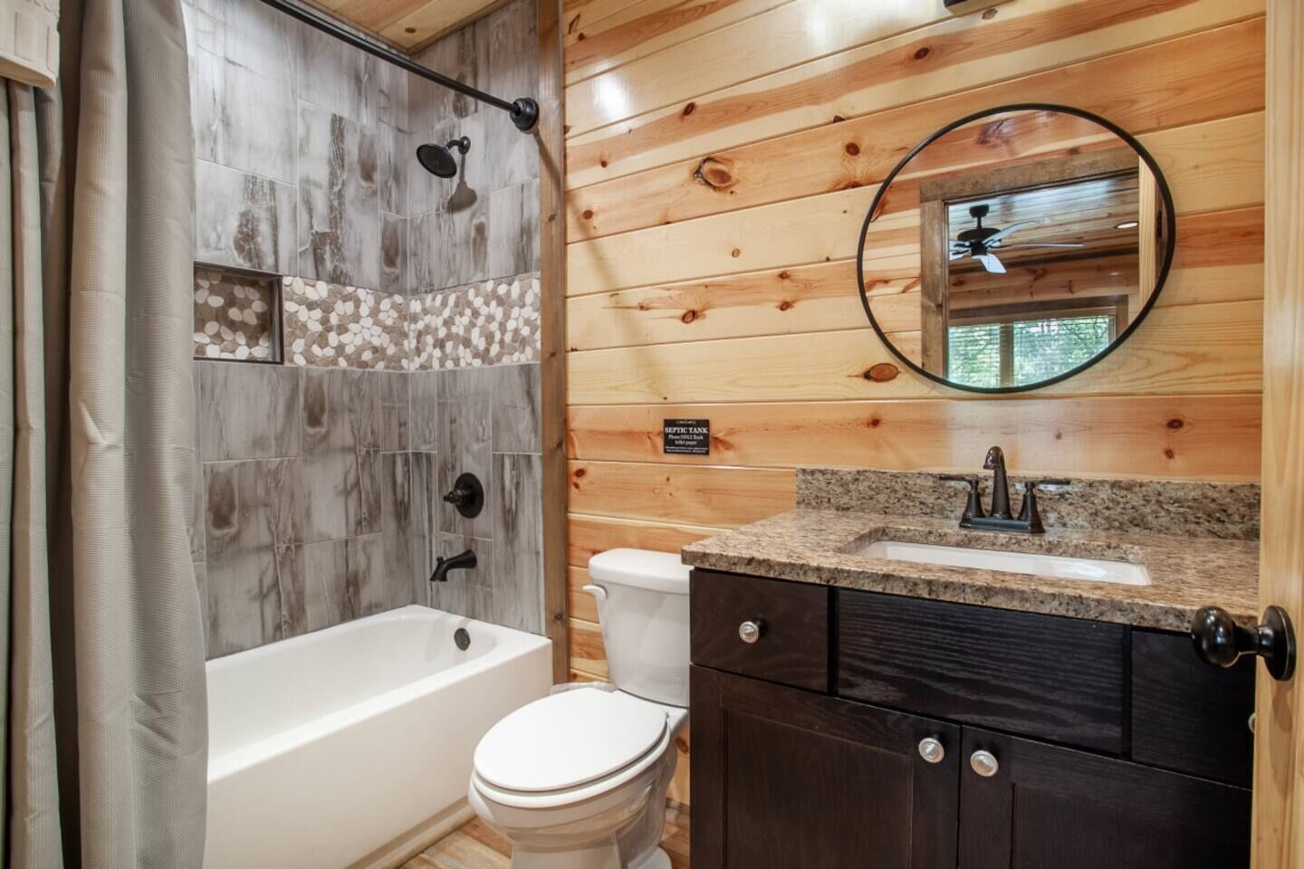 A bathroom with a bathtub, toilet, and sink.
