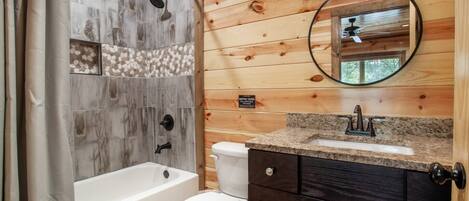 A bathroom with a bathtub, toilet, and sink.