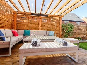 A covered outdoor seating area with a sofa, a table, and a bench. - 37 Devana Gardens (Chester)