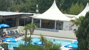 Relax by the pool surrounded by lounge chairs and umbrellas, with a clear view of the water.