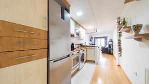 Una cocina moderna con armarios de madera, electrodomésticos de acero inoxidable y una isla central.