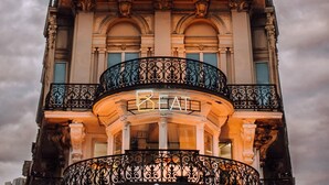 A multi-story building with ornate balconies and a prominent 'REAT' sign.
