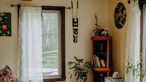 A cozy living room with a wooden ceiling, a round table, a sofa, and a bookshelf.
