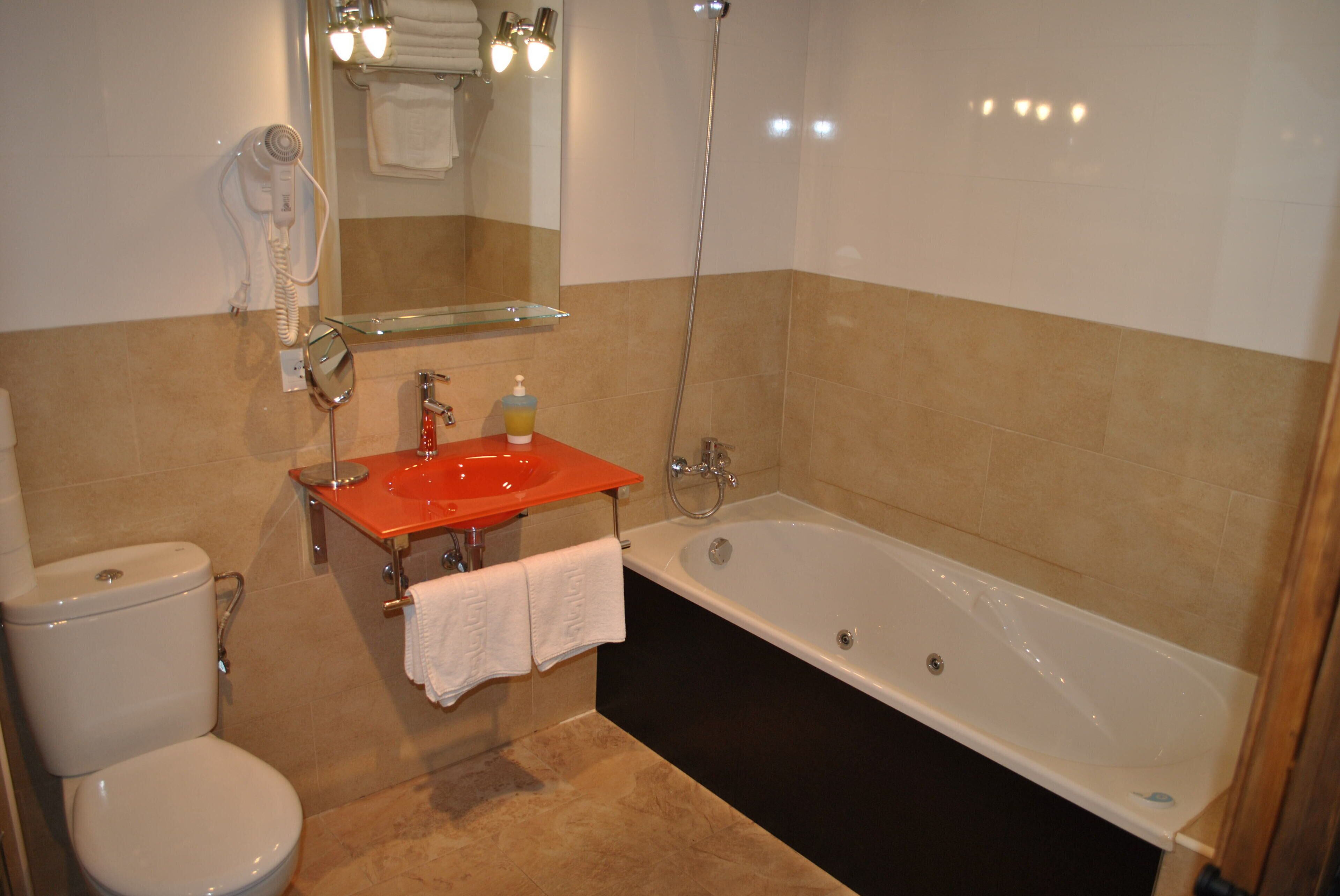 A bathroom with a toilet, sink, and bathtub.