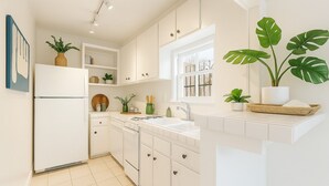 A modern kitchen with white cabinets, a built-in oven, and a window with a view. - Private House/Hollywood Hideaway (West Hollywood)