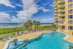 A pool area with a view of the beach, lounge chairs, and a building with balconies. - NEW LISTING!!! Beach Colony West PH3D (18D) - Indoor Pool - HASSLE-FREE CHECK OU (Perdido Key)