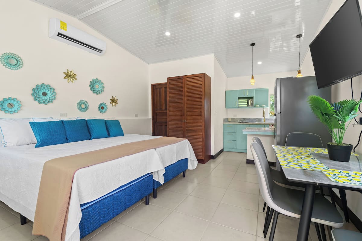 Ein Schlafzimmer mit einem Bett, einem Schreibtisch und einem Esstisch.