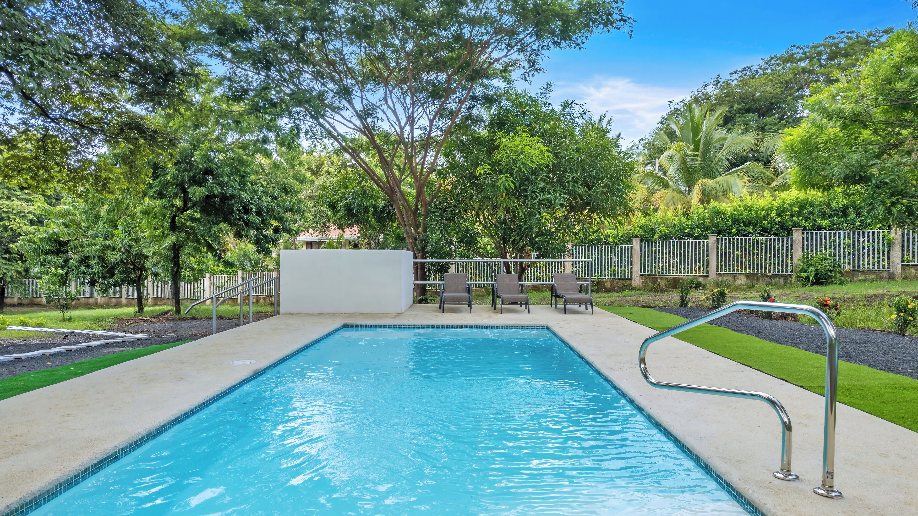 Una piscina al aire libre, sillones reclinables de piscina