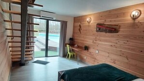 Un dormitorio moderno con pared de madera, cama, escritorio y silla.