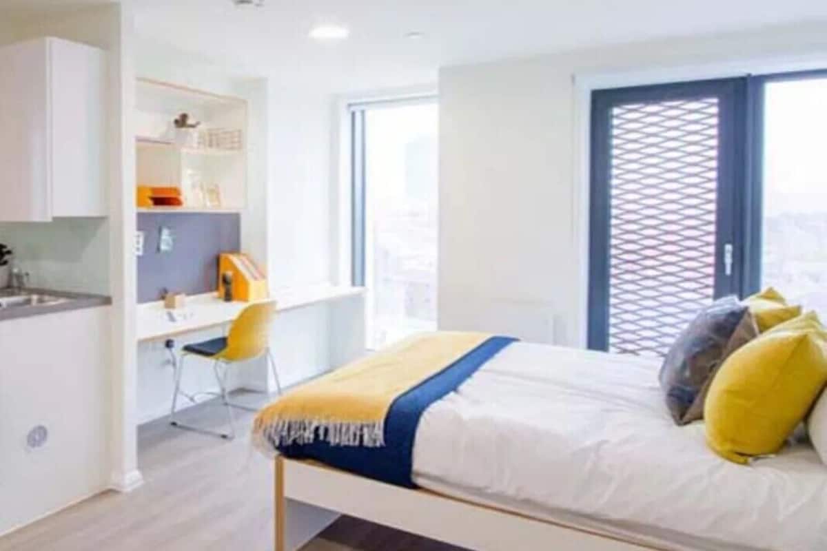 A modern bedroom with a bed, a desk, and a chair.