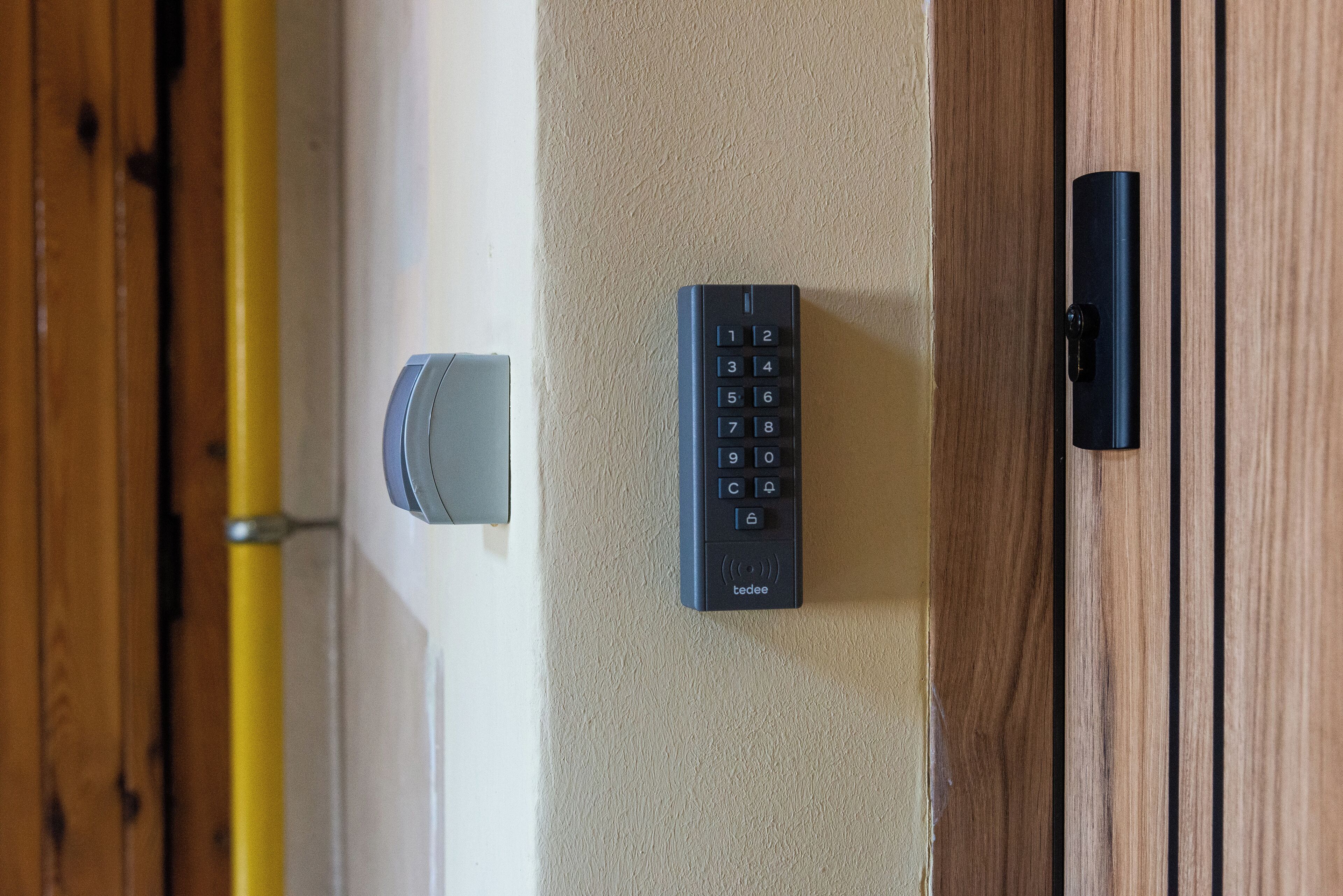 Eine Tür mit Tastatur-Schloss, einem Türgriff und einem vertikalen Griff auf der rechten Seite.