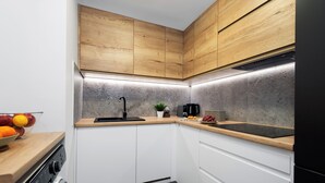 Une cuisine moderne avec des meubles en bois, un four encastré et un plan de travail en granit.