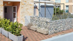 A multi-story residential building with stone and plaster exterior, balconies, and potted plants. - Holiday apartment with balcony and air conditioning (Čižići)