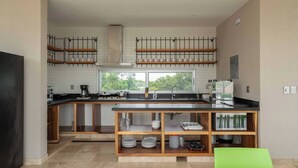 A modern kitchen with a large window, built-in shelves, and a central island. - Private condo ideal for group/family, 12 people (Tulum)