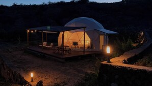A dome-shaped tent with a wooden deck and seating area, surrounded by a stone wall and a dirt path. - Bungalow with Pool in Rural Farm (El Escobonal)