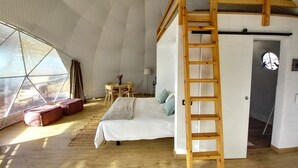 A cozy, well-lit room with a bunk bed, a wooden ladder, a small table with chairs, and a view through a large window. - Bungalow with Pool in Rural Farm (El Escobonal)