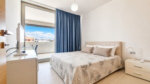 A modern bedroom with a bed, bedside table, lamp, and a view of the outside. - Suite LE Vele 1 in Gallipoli (Gallipoli)