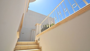 Una escalera con barandillas blancas y vista al cielo.