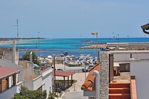 Une vue sur la côte, avec un port de plaisance, des bateaux et un ciel dégagé.
