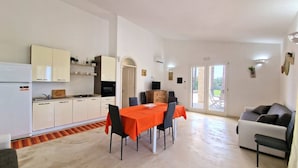 A compact apartment with a kitchen, dining area, and living space. - Villa Paradiso in Marina di Mancaversa (Taviano)