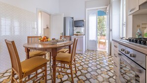 Une cuisine équipée d’une table à manger, de chaises, d’un téléviseur et d’une cuisinière.