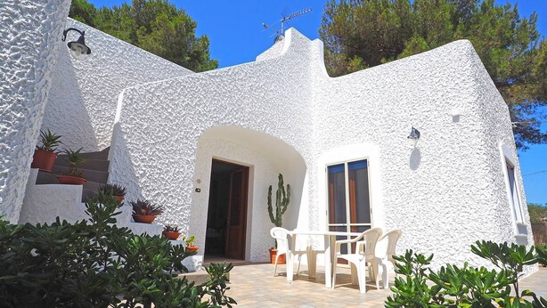 A white stucco building with a patio area, potted plants, and a cactus. - Villa Marechiaro 50 m From the sea 3 Bedrooms 2 Bathrooms (Racale)